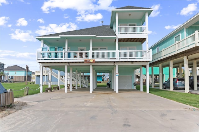 view of front facade with a carport, a porch, stairway, and a shingled roof