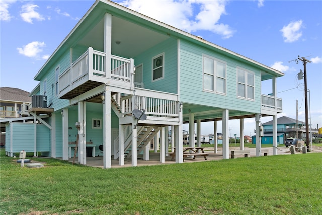 rear view of house with a yard and a wooden deck