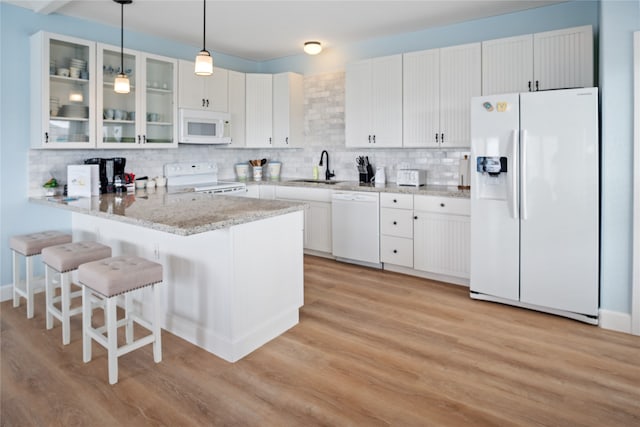 kitchen with white appliances, kitchen peninsula, decorative backsplash, and light hardwood / wood-style floors