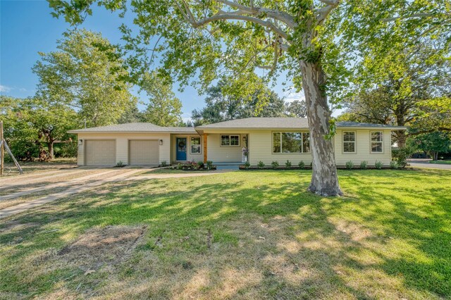 ranch-style home featuring a garage, a front yard, and driveway