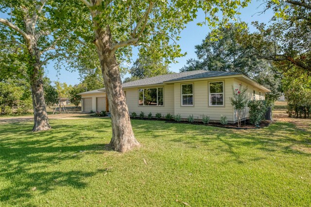 back of house featuring a garage and a yard