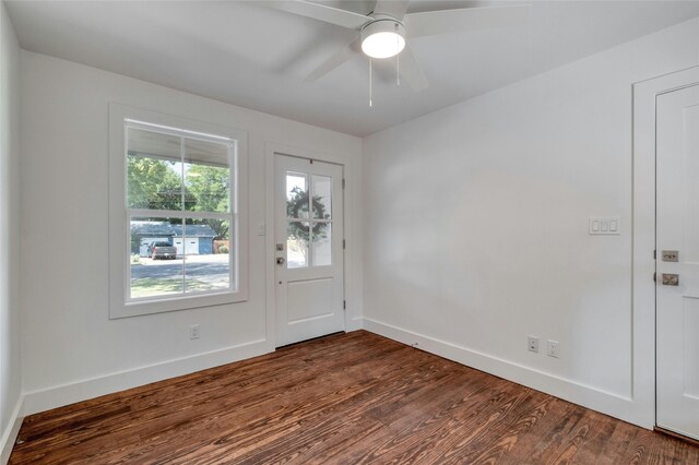 foyer with dark wood-style flooring, a ceiling fan, and baseboards