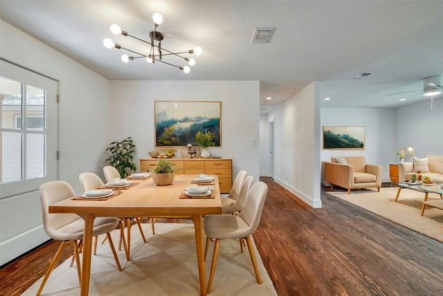 dining room featuring a notable chandelier, baseboards, visible vents, and wood finished floors