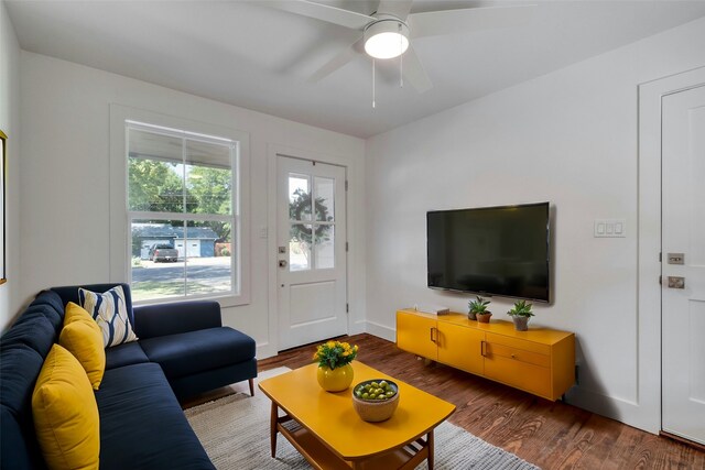 living room featuring ceiling fan, baseboards, and wood finished floors