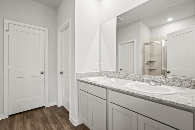 bathroom with wood-type flooring, an enclosed shower, and vanity