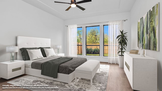 9007 Pleasant Cv, Missouri City, TX 77459 - bedroom with a ceiling fan, a tray ceiling, and wood finished floors