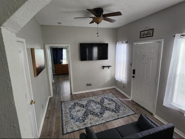 entryway with ceiling fan, dark hardwood / wood-style floors, and a textured ceiling