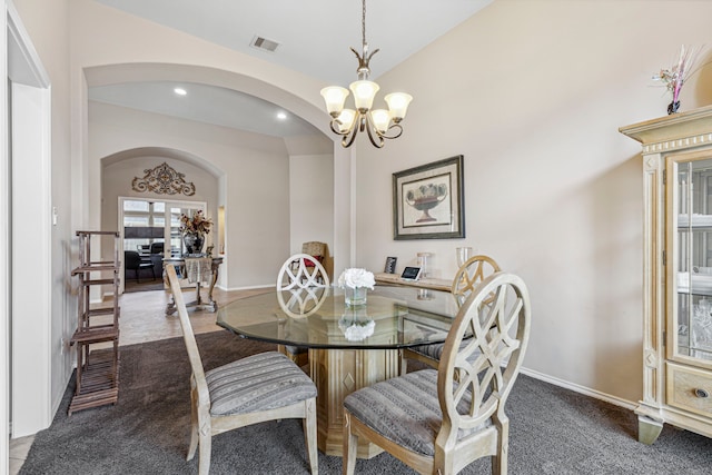 dining space featuring carpet floors, a notable chandelier, and vaulted ceiling