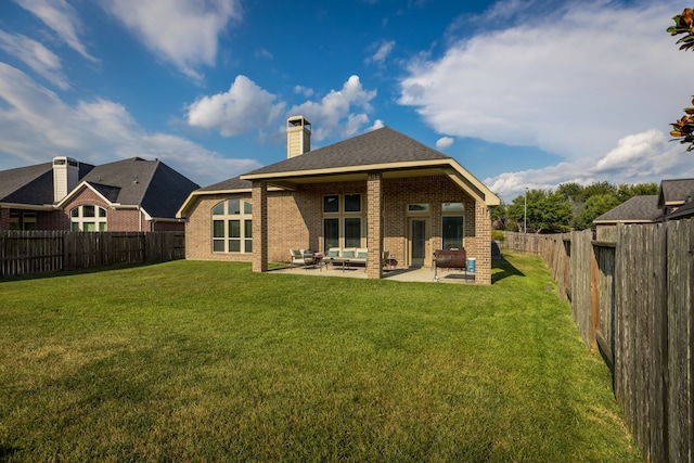 rear view of house featuring a patio and a yard