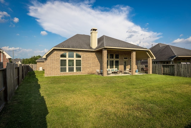 rear view of property with a patio area and a lawn