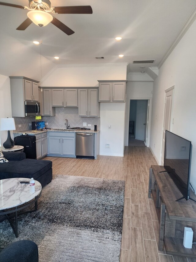 living room featuring ceiling fan, sink, light hardwood / wood-style flooring, crown molding, and lofted ceiling