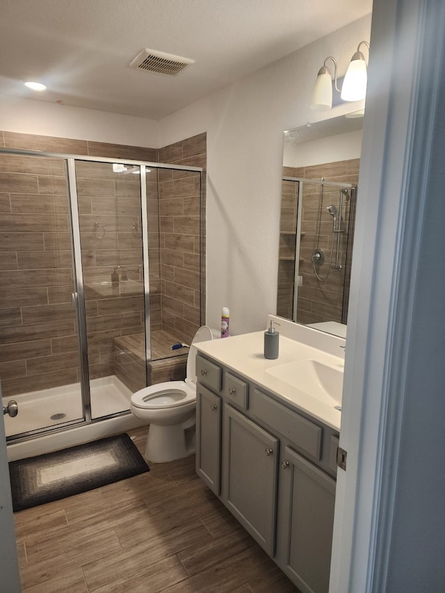 bathroom with vanity, toilet, and an enclosed shower