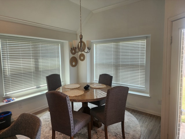 dining area with hardwood / wood-style floors, vaulted ceiling, ornamental molding, plenty of natural light, and a chandelier