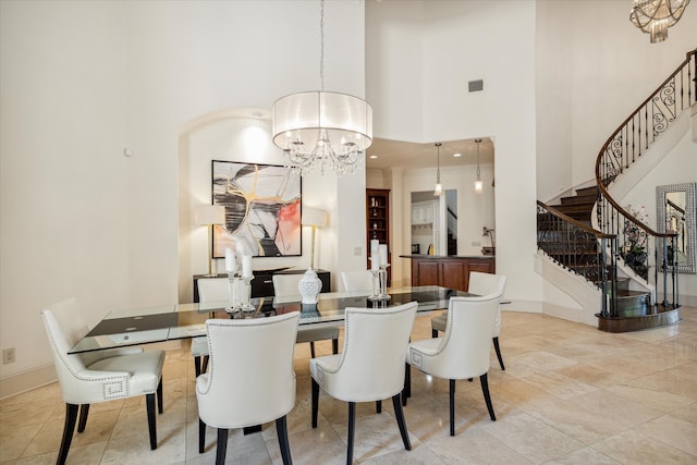 dining space with a high ceiling, a chandelier, and light tile patterned floors