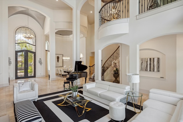 living room with tile patterned floors, french doors, a towering ceiling, and a chandelier