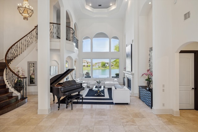 interior space with an inviting chandelier, a high ceiling, and a water view