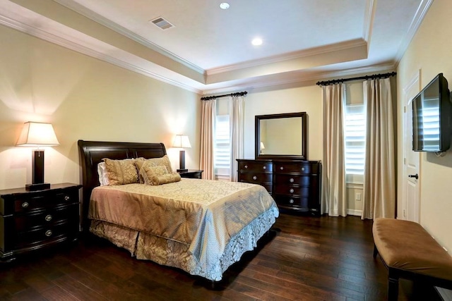 bedroom with a tray ceiling, crown molding, and dark hardwood / wood-style floors