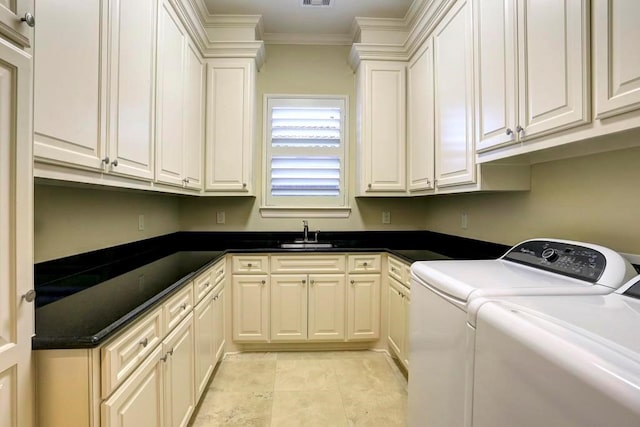 laundry area featuring sink, washing machine and dryer, ornamental molding, cabinets, and light tile patterned floors