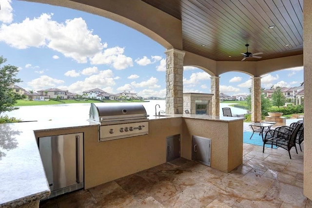 view of patio with ceiling fan, sink, a grill, and an outdoor kitchen