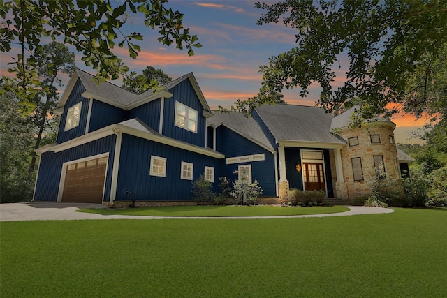 view of front of property featuring a garage and a lawn