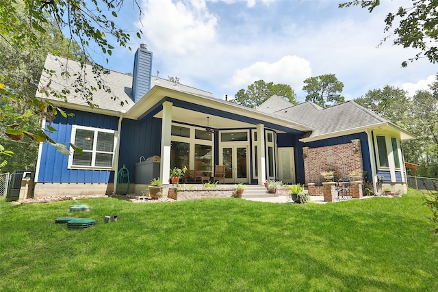 rear view of house featuring a lawn, ceiling fan, and french doors