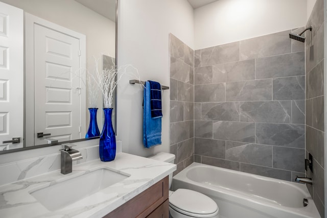 full bathroom featuring toilet, vanity, and tiled shower / bath