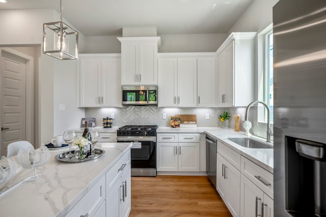 kitchen with white cabinets, stainless steel appliances, plenty of natural light, and sink