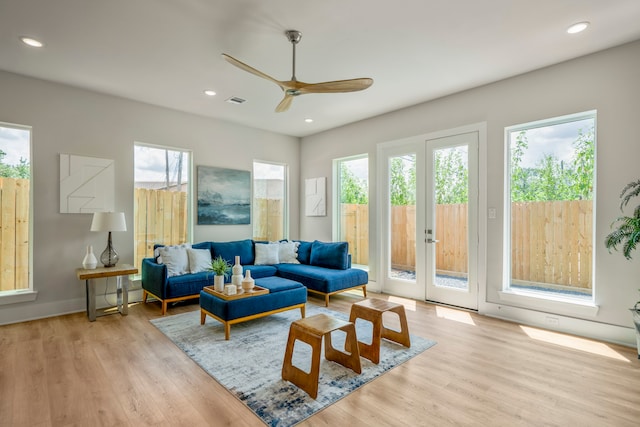 living room featuring light hardwood / wood-style floors, a wealth of natural light, and ceiling fan