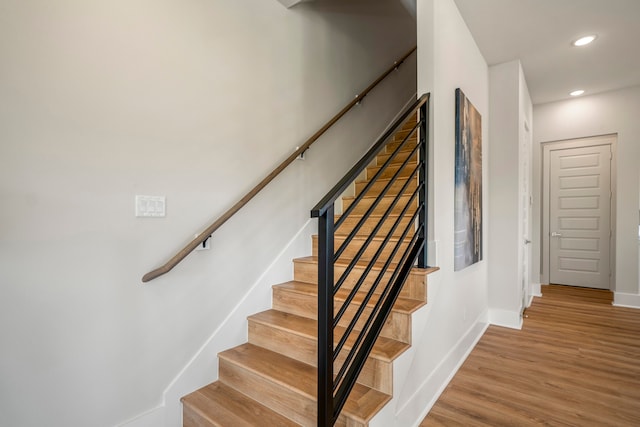 stairs featuring hardwood / wood-style floors