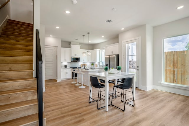 dining area with light wood-type flooring and sink