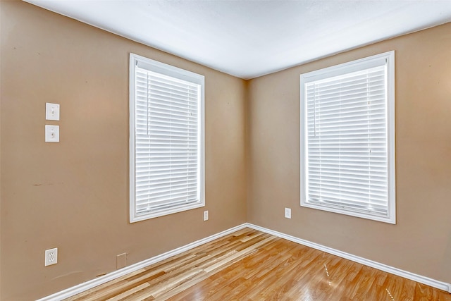unfurnished room featuring baseboards and light wood-type flooring
