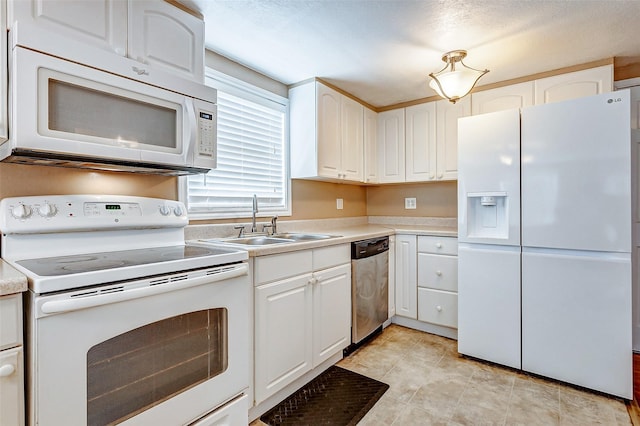 kitchen featuring white cabinets, white appliances, light countertops, and a sink