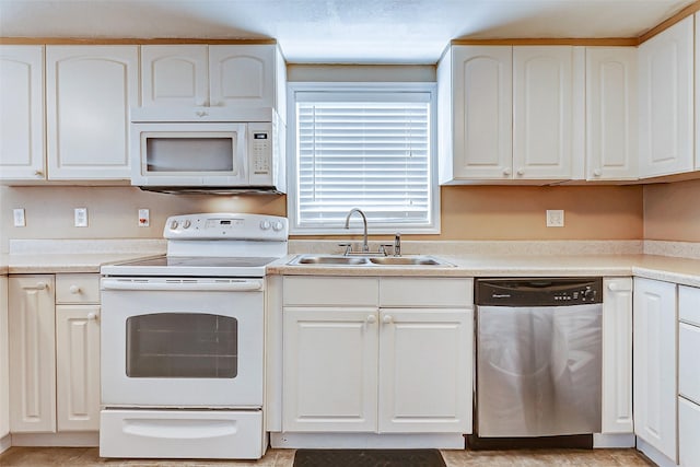 kitchen with light countertops, white appliances, white cabinetry, and a sink