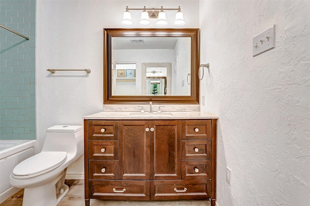 full bathroom featuring visible vents, toilet, a textured wall, vanity, and bathing tub / shower combination