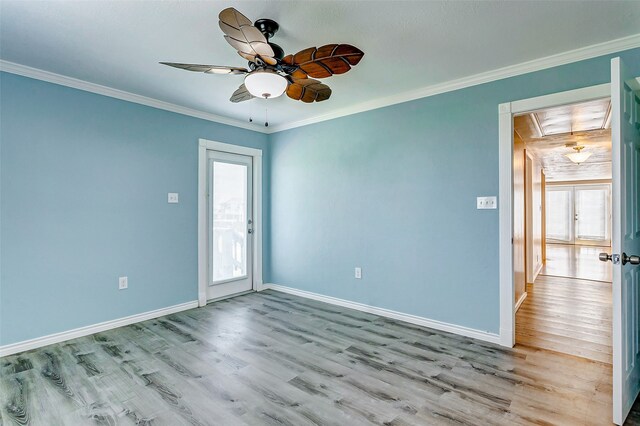 empty room featuring hardwood / wood-style floors, crown molding, and ceiling fan