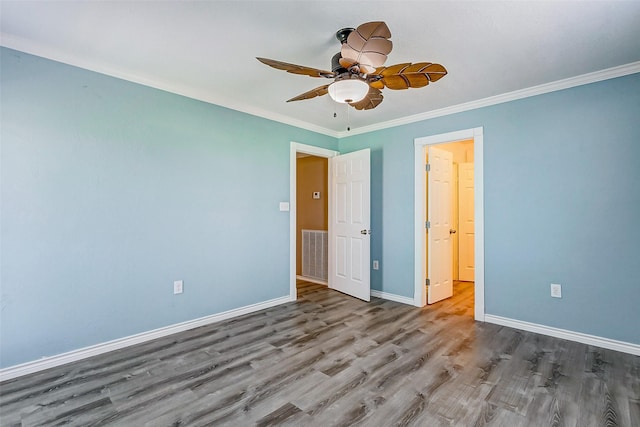 unfurnished bedroom featuring visible vents, baseboards, a ceiling fan, crown molding, and wood finished floors