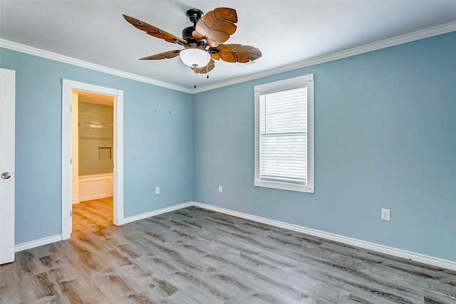 spare room featuring ceiling fan, baseboards, ornamental molding, and wood finished floors