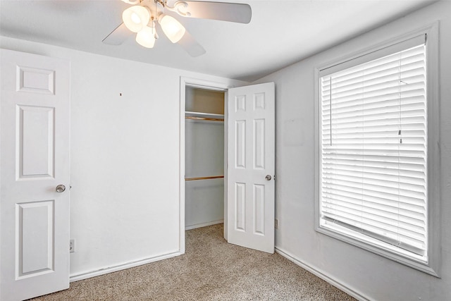 unfurnished bedroom with carpet, a closet, baseboards, and ceiling fan