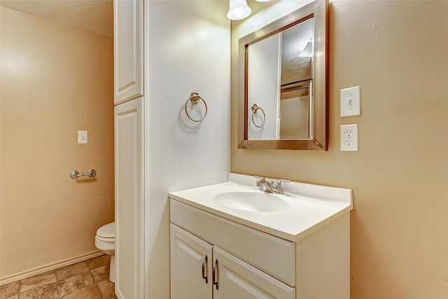 bathroom featuring vanity, baseboards, and toilet