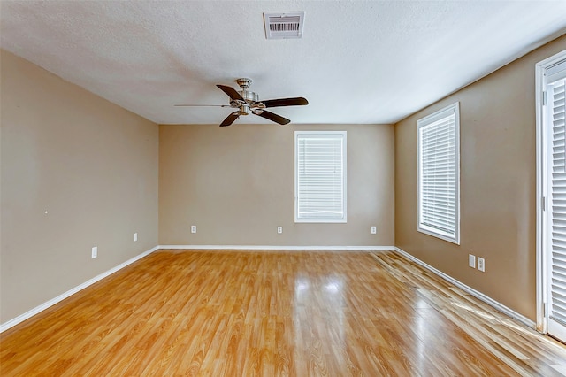 empty room featuring a textured ceiling, ceiling fan, and light wood-type flooring