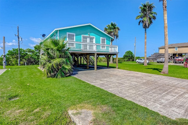 exterior space with a carport, concrete driveway, and a front yard