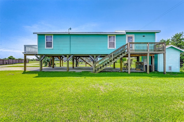 rear view of property with a lawn, a wooden deck, and stairway