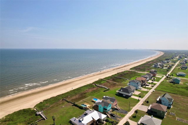 birds eye view of property with a water view and a beach view