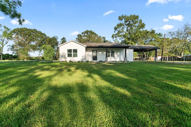 rear view of house featuring a yard