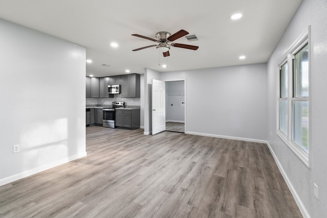 unfurnished living room with light hardwood / wood-style floors, plenty of natural light, and ceiling fan