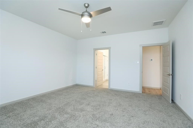 unfurnished bedroom with ceiling fan, light carpet, and ensuite bathroom