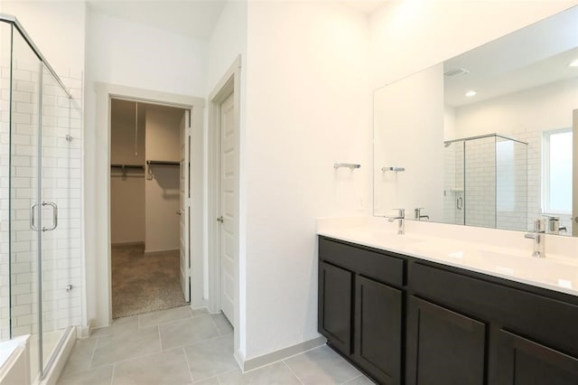 bathroom featuring tile patterned flooring, a shower with door, and vanity