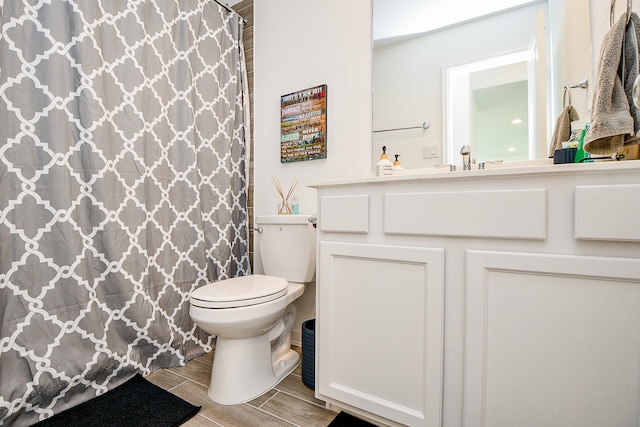 bathroom featuring toilet, walk in shower, and vanity