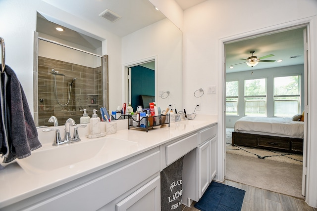 bathroom featuring ceiling fan, a shower with door, and vanity