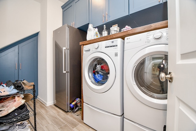 washroom featuring independent washer and dryer, light wood-type flooring, and cabinets